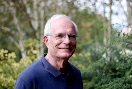 A portrait of Geoffrey Wilkinson with greenery in the background